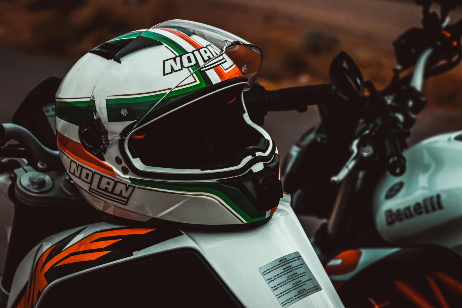 Detailed shot of a racing motorcycle helmet on a sports bike, featuring vibrant colors and brand logos.