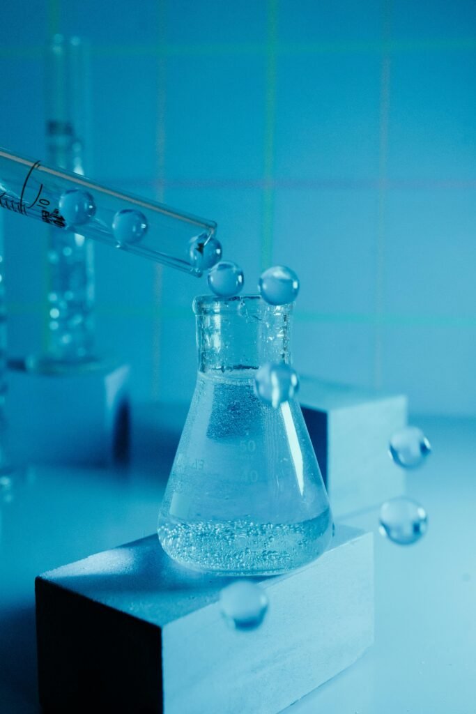 Laboratory experiment showcasing a beaker with bubbling liquid and pipette against a blue backdrop.